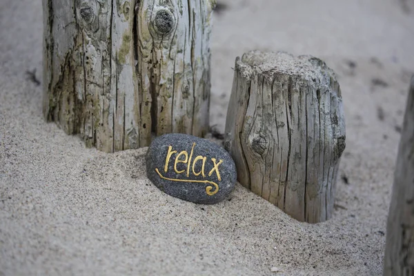 Relajarse Letras en guijarros en Sandy Beach —  Fotos de Stock