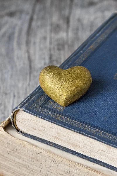 Nostalgische gouden hart op oude boeken — Stockfoto