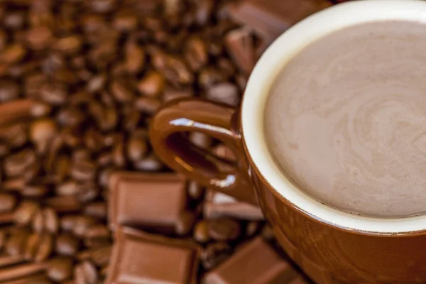 Chocolat chaud dans une tasse et des barres de chocolat — Photo