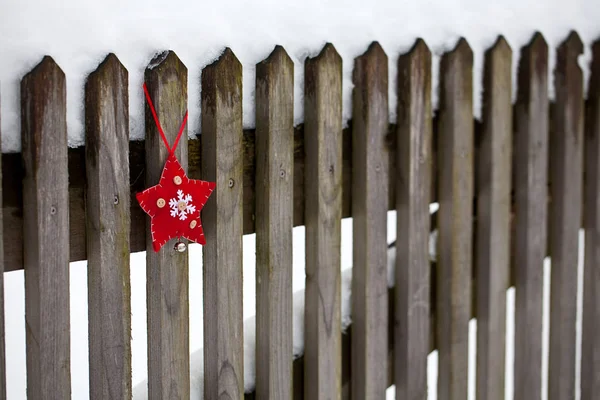 古いフェンスの赤い白いクリスマススターの装飾 — ストック写真