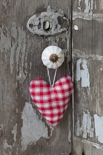 Coeur en tissu blanc rouge suspendu au bouton — Photo