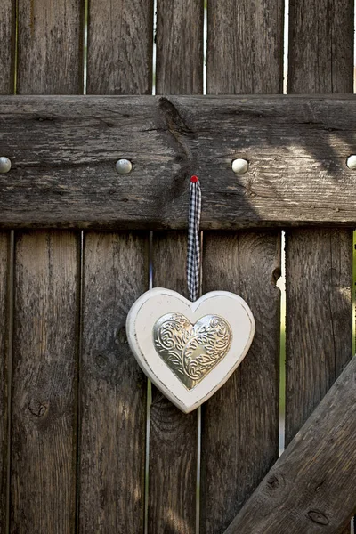 Bílé srdce visí na starých dveřích — Stock fotografie