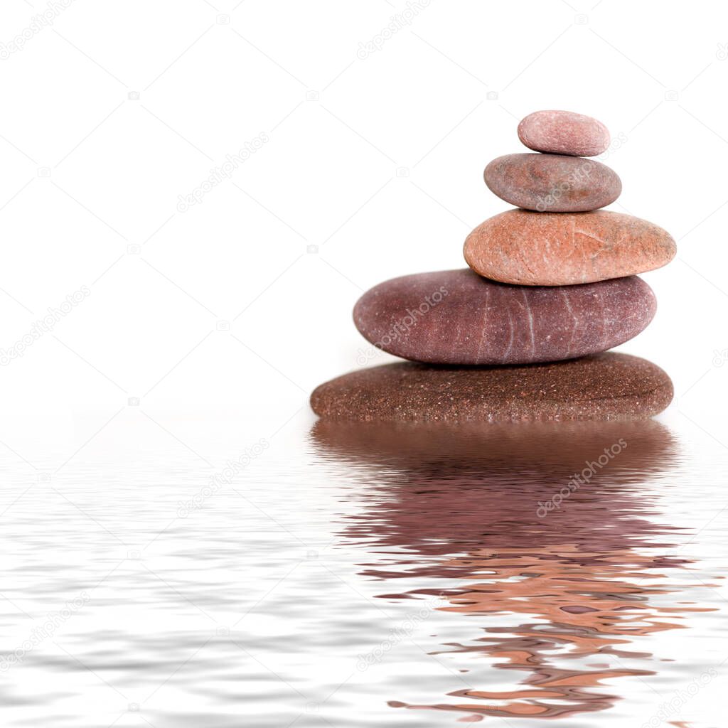Balanced pebble stone cairn reflecting in water across a white background