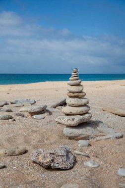 Endülüs, İspanya 'da yalnız bir plajda oluşturulan taş cairn tebrik kartı, trafik projesi veya hediye paketi için mükemmel.