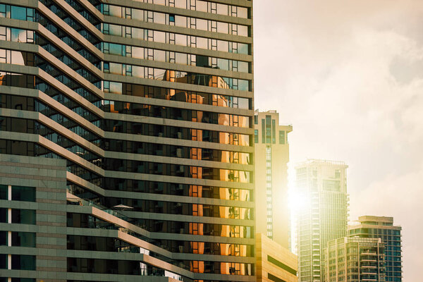 View of modern hotel lined with glass as contemporary residential high-rise buildings on background in Tel Aviv, Israel.