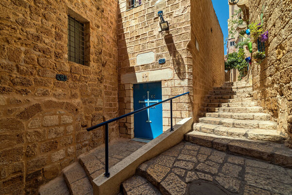Stone stairs on narrow street among ancient and medieval walls in small town of Jaffa, Israel.