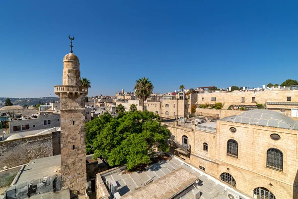 Old minaret among typical houses under blue sky in Old City of J — Stock Photo, Image