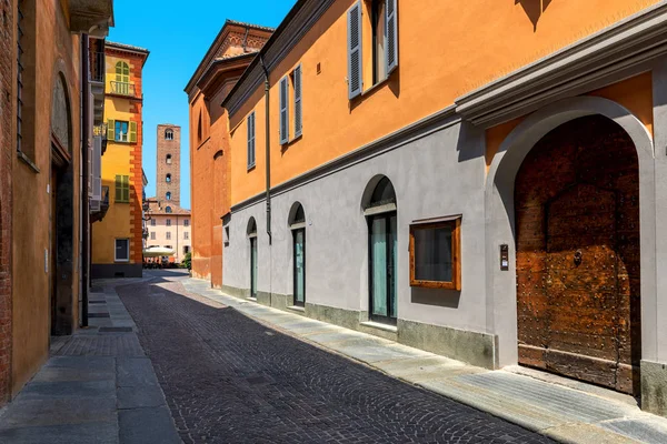 Estreito, rua de paralelepípedos entre antigas casas coloridas em Alba, Itália . — Fotografia de Stock