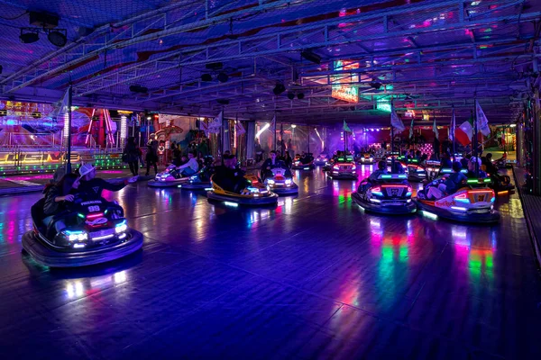 La gente monta en coches de choque en Luna Park en Alba, Italia . — Foto de Stock