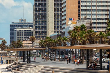 TEL AVIV, ISRAEL - 19 Temmuz 2017: Tel Aviv 'deki modern otel binaları boyunca gezinen insanlar - Akdeniz kıyılarındaki şehir, İsrail' in ekonomik ve teknolojik merkezi.