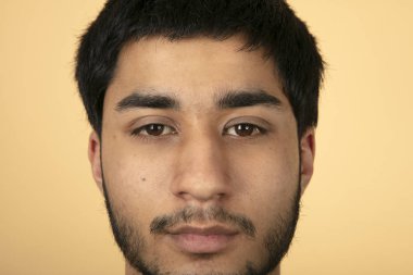 Bej arka planda güzel siyah saçlı adam.