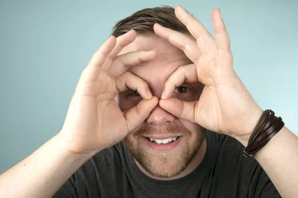 Genç Adam Bir Stüdyo Portre Kameraya Bakar Gibi Gözlerinin Parmaklarıyla — Stok fotoğraf