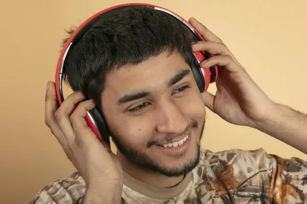 Hombre Joven Con Auriculares Escuchar Música Sobre Fondo Beige — Foto de Stock