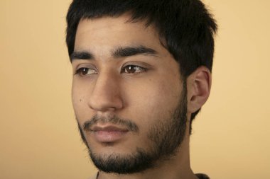 Bej arka planda güzel siyah saçlı adam.