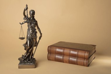 Bej renkli arka plan üzerinde eski kitaplar ile Justizia şekil