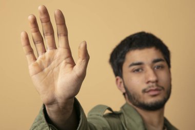 Genç adam dur işaretini eliyle gösteriyor.