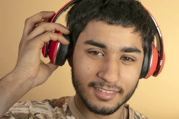 Young Man Met Koptelefoon Luisteren Naar Muziek Beige Achtergrond — Stockfoto