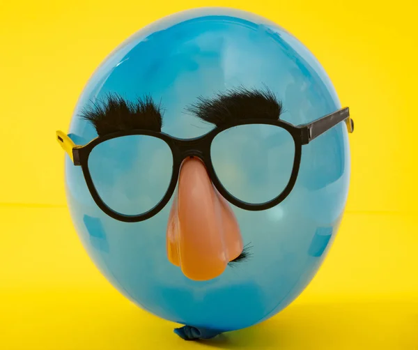 Blauwe Ballon Met Grappig Masker Gele Achtergrond — Stockfoto