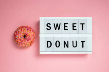 Pembe bir arka plan üzerinde Lightbox ile lezzetli Donut