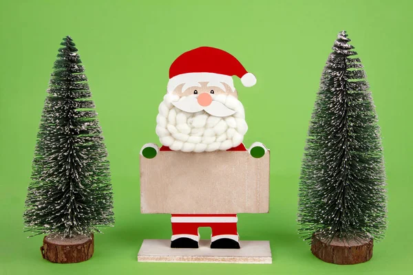 Декоративный Деревянный Санта Клаус Игрушечными Деревьями Зеленом Фоне — стоковое фото