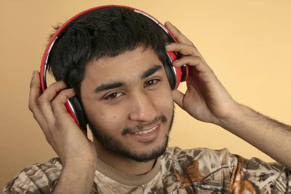 Young Man Met Koptelefoon Luisteren Naar Muziek Beige Achtergrond — Stockfoto