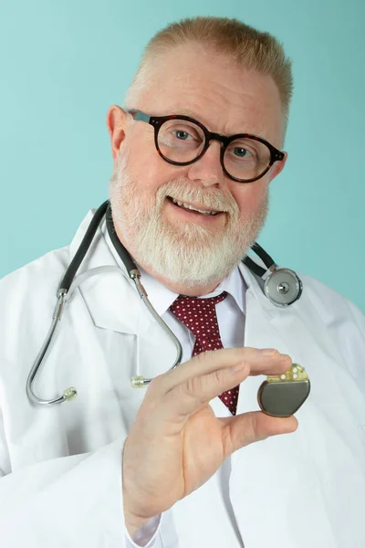 Αρσενικό Γιατρός Κρατάει Βηματοδότη Μπροστά Από Την Κάμερα Μπλε Φόντο — Φωτογραφία Αρχείου