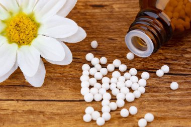 Homeopati tıp ile ahşap arka plan üzerinde bir çiçek çiçek.