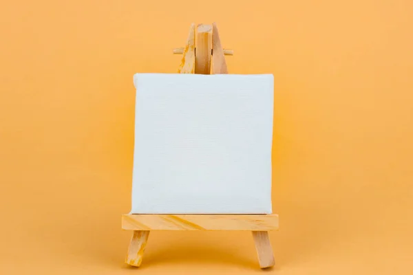 オレンジ色の背景の空白のアート イーゼル — ストック写真