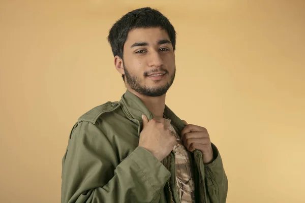 Молодой Человек Зеленой Военной Куртке Бежевом Фоне — стоковое фото