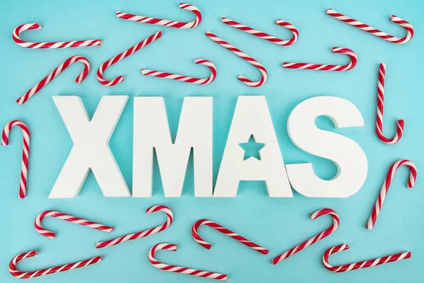 Şeker Çubukları ve ahşap XMAS Mavi ışık arka planı harfleri