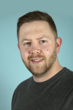 Kameraya bakan sakallı genç adamın ön stüdyo portresi.