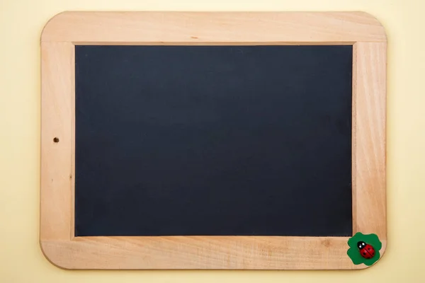 黄色の背景に小さな木製のジャニックビートルを持つ装飾的なBlackboard — ストック写真