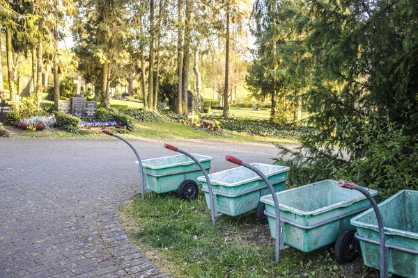 Wielwagens Met Plastic Container Een Rij Een Begraafplaats — Stockfoto