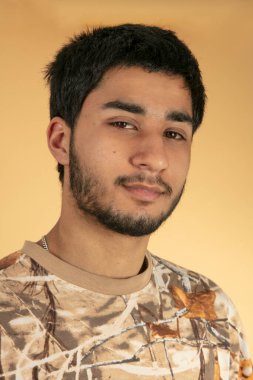 Bej arka planda arkadaş canlısı genç adam