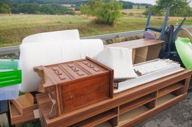 Atılmış mobilyalar ve ev eşyaları güzel bir doğal manzarayı kirletiyor ve yasadışı boşaltım sorununu vurguluyor.