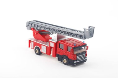 Merdiveni genişleten kırmızı ve gri oyuncak itfaiye aracı, beyaz arka planda izole edilmiş, oyun zamanı veya eğitim amaçlı olarak hazır..