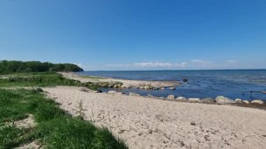 Huzurlu baltık deniz suları kumlu bir kumsalla buluşur ve sakin bir sahil manzarası yaratır.
