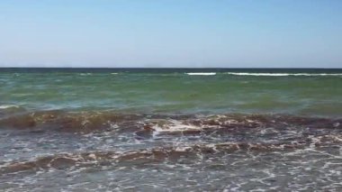 Sakin okyanus dalgaları yavaşça sahile çarpar ve sakin bir atmosfer yaratır.