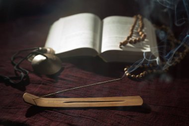 Koku çubuğuyla açık bir kitap.