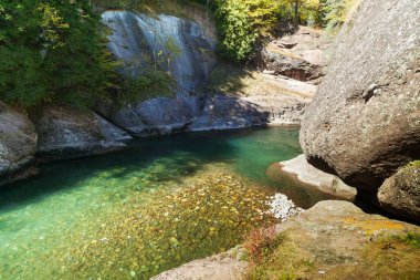 Büyük kayalıkları olan dağ nehrinin durgun suları