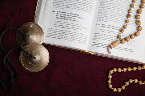 Sanskritçe ilahi boncuklarla kutsal kitabı aç