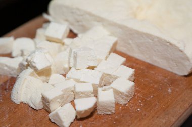Paneer 'in yakın plan kesme tahtasında parçalara ayrılmış hali.