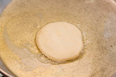 Kızartma tavasında bhatura hamuru ve yağ.