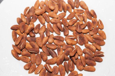 Beyaz tabakta kavrulmuş badem yakın plan.