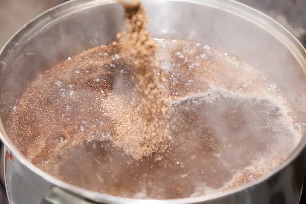 Closeup of pouring brown powder into bowl