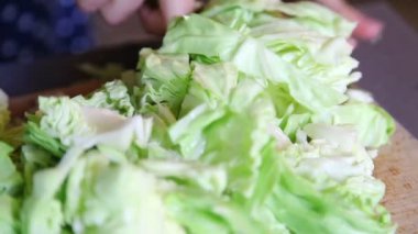 Ahşap tahtada lahana kesen ellere yakın çekim