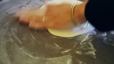 Hamuru un ile düzleştiren ellerin yakınlaşması