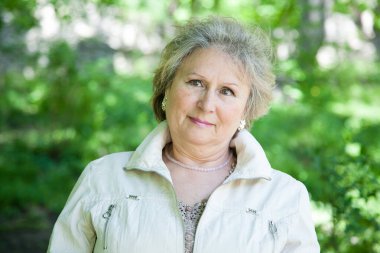 Yaşlı bir kadın parkın dışında düşünüyor ve düşünüyor.