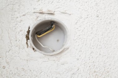 Duvarda elektrik kabloları olan ve seçici odaklı bir delik.