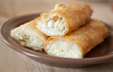 Kalın bir tabakta pamuk peynirli turtalar.